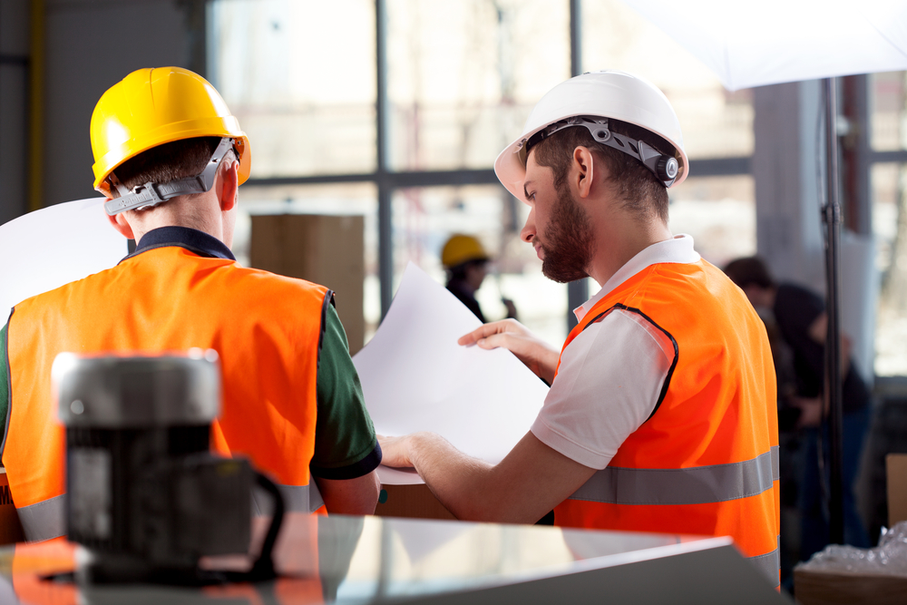 Male factory worker and supervisor are analyzing plans-3